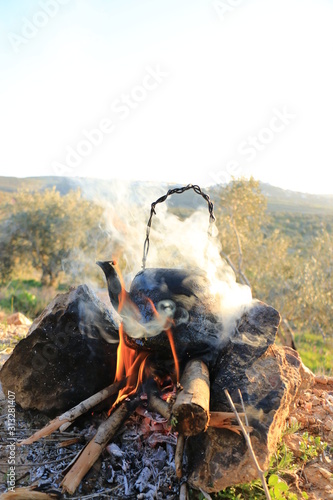 Obraz na płótnie A teapot on the Firewood in nature w salonie