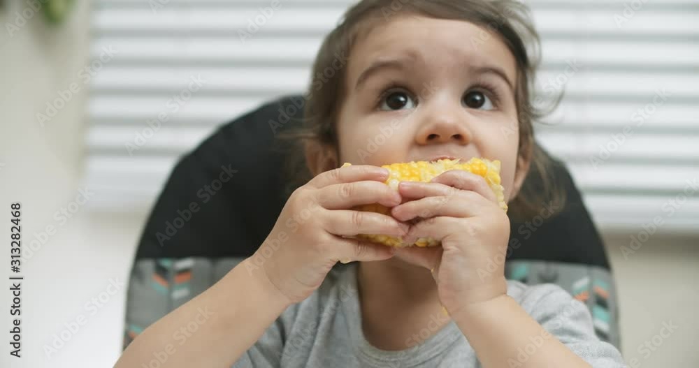 Cute little girl eating corn on cob. Shot in 4K RAW on a cinema camera. Cute little girl eating corn on cob. Shot in 4K RAW on a cinema camera.