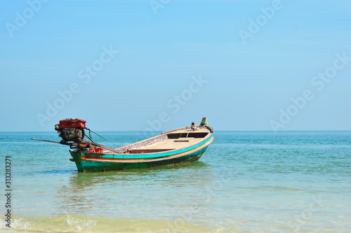 Scenic landscape with boats on the beach. Colorful wooden ships on the water. Tropical beach and fishing boats.