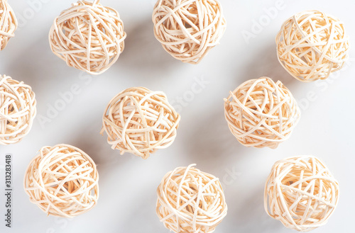 Natural color rattan balls on a gray background, top view, flat lay, minimal. Soft pastel colors.