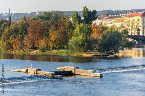 Strelecky Island with weir on Vltava river near National Theatre and the Charles Bridge, Prague, Czech Republic, sunny autumn day photo