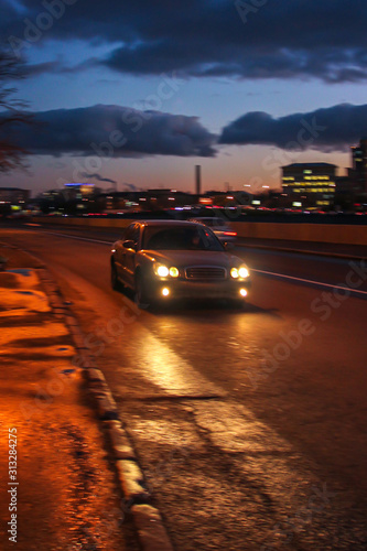 Car is moving at high speed at wet and cold night. Motion blur. Defocused image.