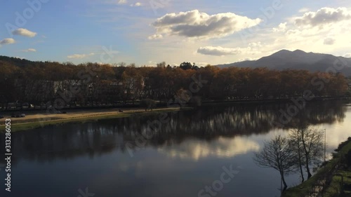 Aerial, pan, drone shot of the Lima river, on a sunny autumn day, in Ponte de Lima, Viana do castelo, Northern Portugal