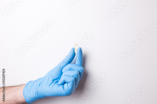 hand in glove, hand hold the pill on white background