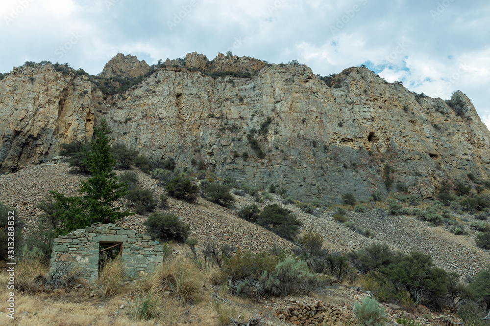 Abandoned Stone Building at the Bottom of a Hill in Bayhorse Ghost Town, Idaho, USA