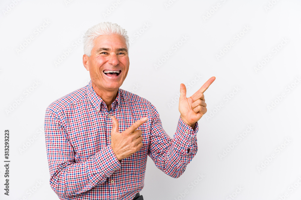 Senior caucasian man isolated pointing with forefingers to a copy space, expressing excitement and desire. Senior caucasian man isolated pointing with forefingers to a copy space, expressing excitement and desire.