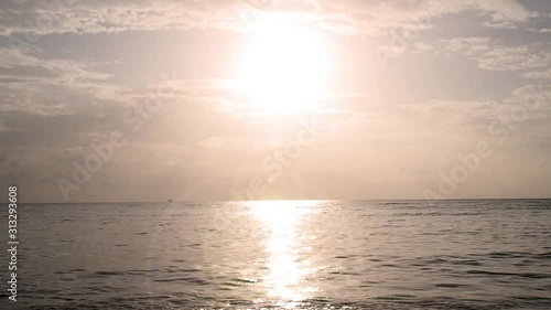 Sunset over sea. Sun light reflect with sea wave surface and flare. Summer time for vacation and holiday.