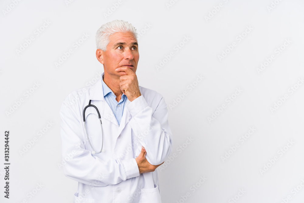 Mature caucasian doctor man looking sideways with doubtful and skeptical expression. Mature caucasian doctor man looking sideways with doubtful and skeptical expression.
