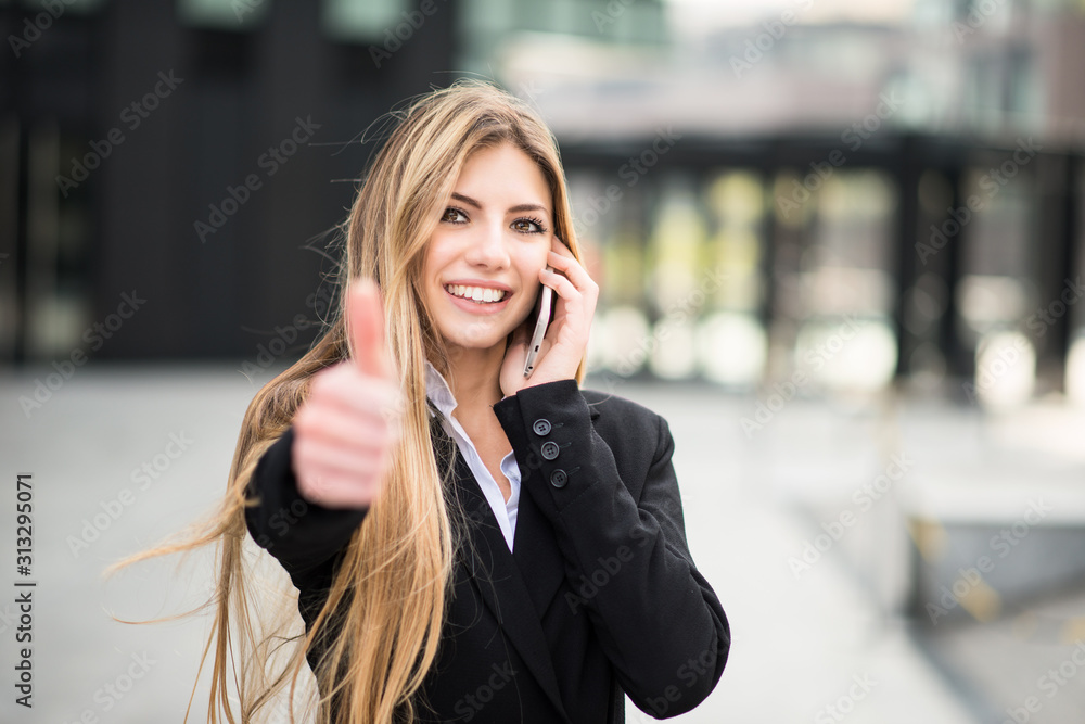 Smiling business woman talking on the phone and thumbs up - obrazy, fototapety, plakaty 