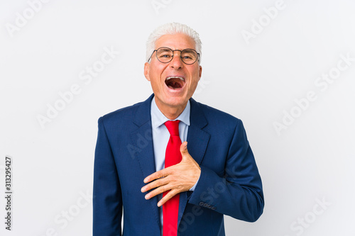 Middle aged caucasian business man isolated laughs out loudly keeping hand on chest.