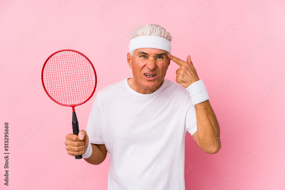 Naklejka premium Middle aged man playing badminton isolated showing a disappointment gesture with forefinger.