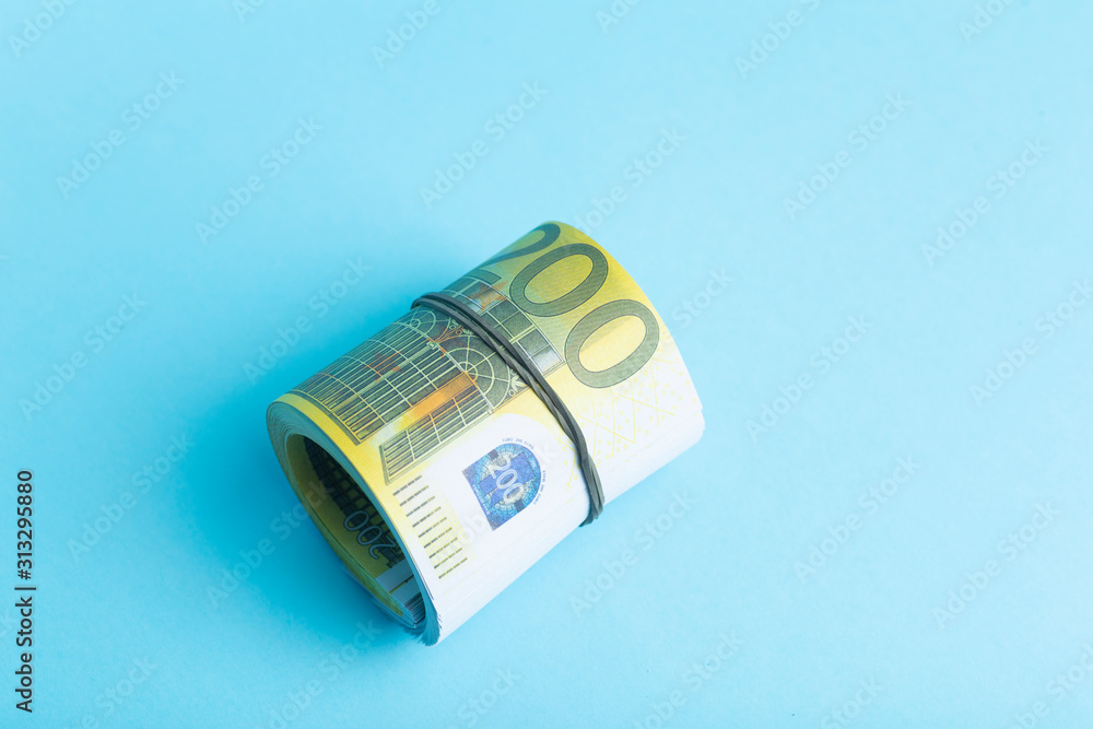 Money and income concept. Euro cash banknotes on a blue background. Saving and spending money Money and income concept. Euro cash banknotes on a blue background. Saving and spending money