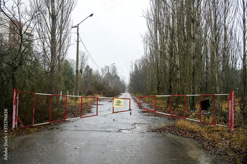 The barrier is blocking the road to ghost town of Prypiat in Chornobyl Exclusion Zone, Ukraine. December 2019