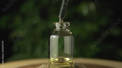 Pipette droplet dosing licensed cannabis CBD oil for medical purposes. Hydroponic biological and ecological hemp plant and herbal pharmaceutical clinic study concept.