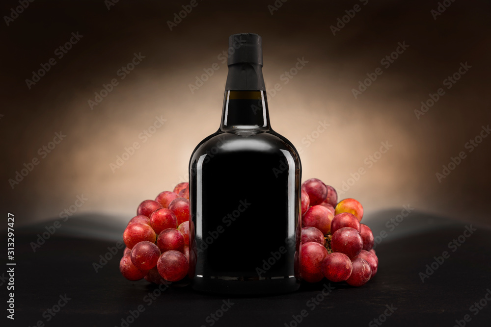 Obraz premium Czarna butelka czerwonego wina z winogronami packshot