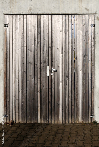 gray planks of a wooden door in concrete wall