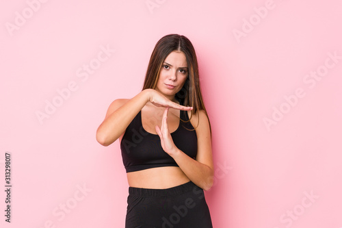 Young fitness caucasian woman isolated showing a timeout gesture.