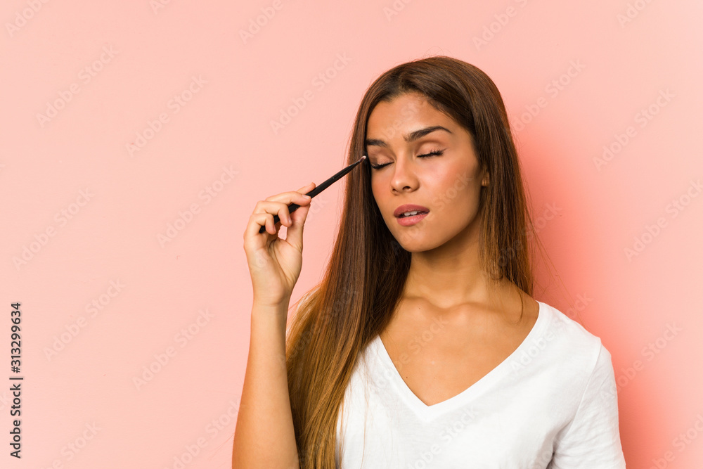 Fototapeta premium Young caucasian woman holding a eyebrush isolated