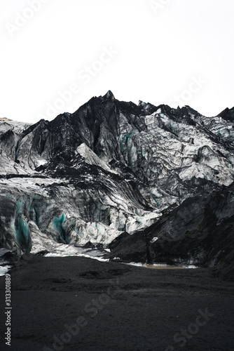 Glacier Mountain in Iceland with Black Sand covering the ground and the glacier