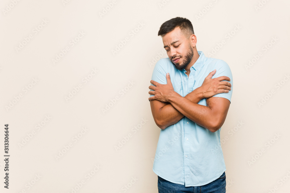 Young south-asian man hugs, smiling carefree and happy. Young south-asian man hugs, smiling carefree and happy.