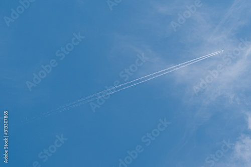 Plane in the sky. Blue background and clouds.