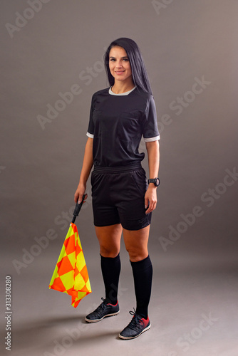 Фотография Beautiful Soccer Referee with flag in hand looking at camera and smile