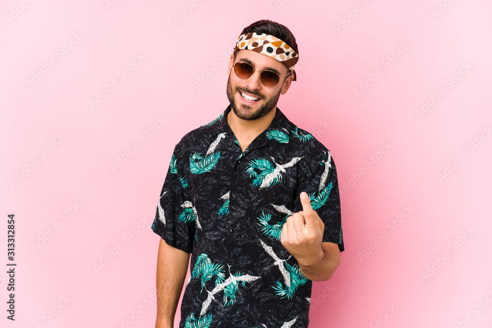 Young hipster man isolated pointing with finger at you as if inviting come closer. Young hipster man isolated pointing with finger at you as if inviting come closer.