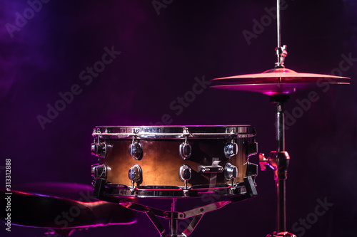 Drums and drum set. Beautiful blue and red background, with rays of light. Beautiful special effects of smoke and lighting. Musical instrument. Close-up photo. photo