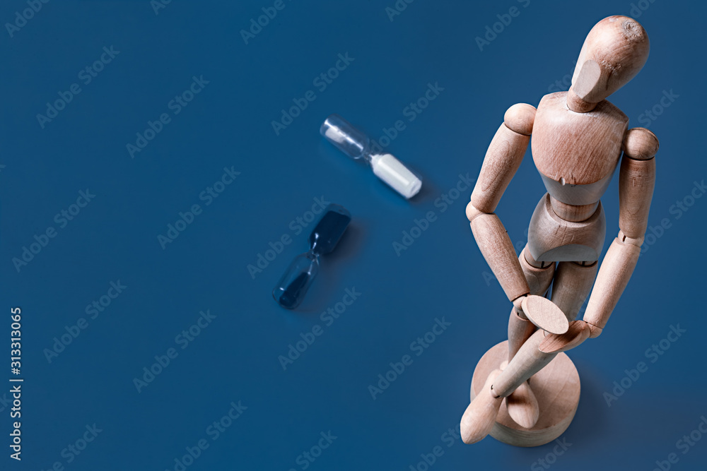 The wooden man figurine on a blue background. The wooden man figurine on a blue background.