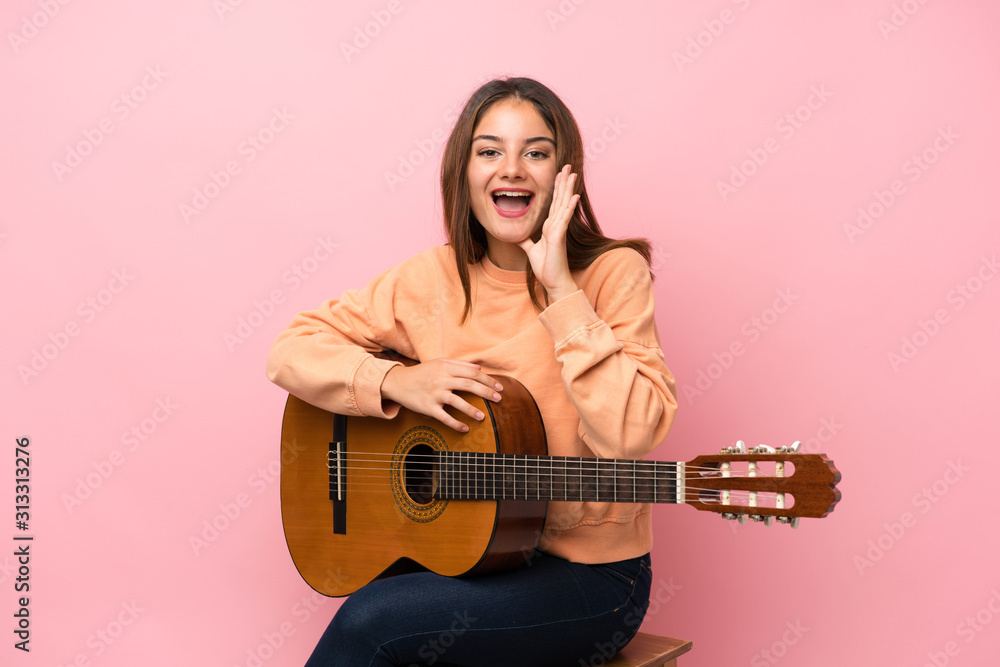 Young brunette girl with guitar over isolated pink background shouting with mouth wide open Young brunette girl with guitar over isolated pink background shouting with mouth wide open