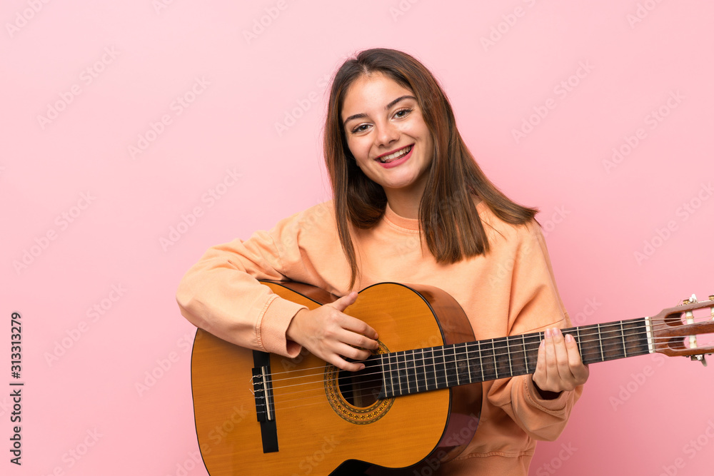 Young brunette girl with guitar over isolated pink background Young brunette girl with guitar over isolated pink background