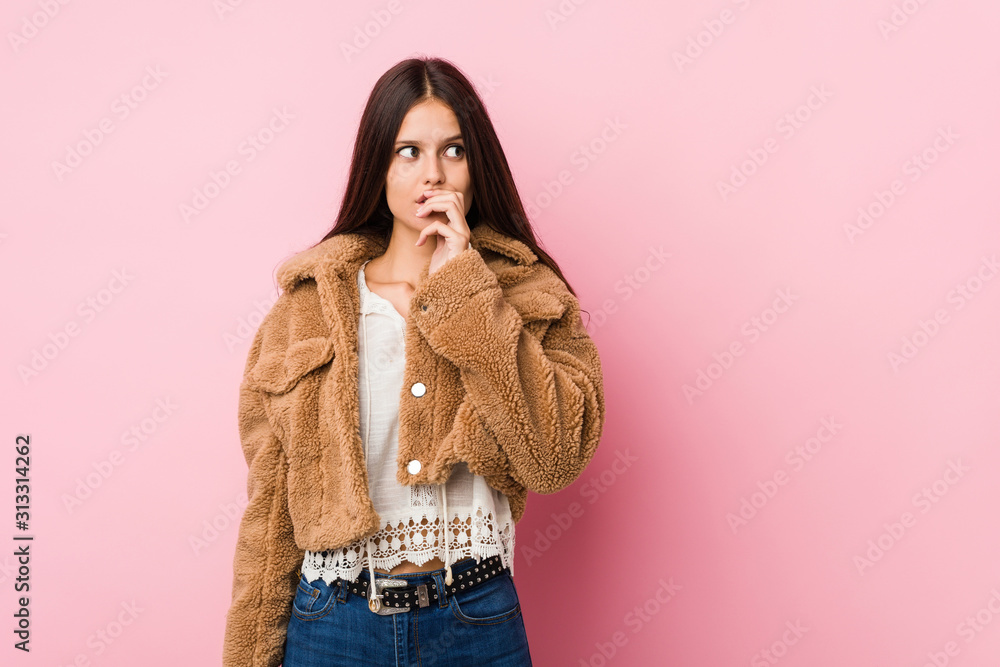 Young cute woman thoughtful looking to a copy space covering mouth with hand. Young cute woman thoughtful looking to a copy space covering mouth with hand.