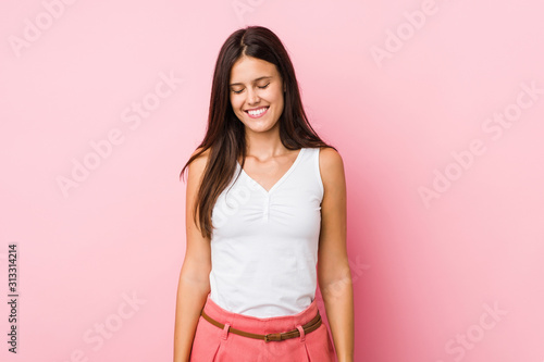 Young cute woman laughs and closes eyes, feels relaxed and happy. © Asier