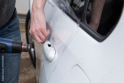 Installing a protective film on the car body to protect the paint on the car.