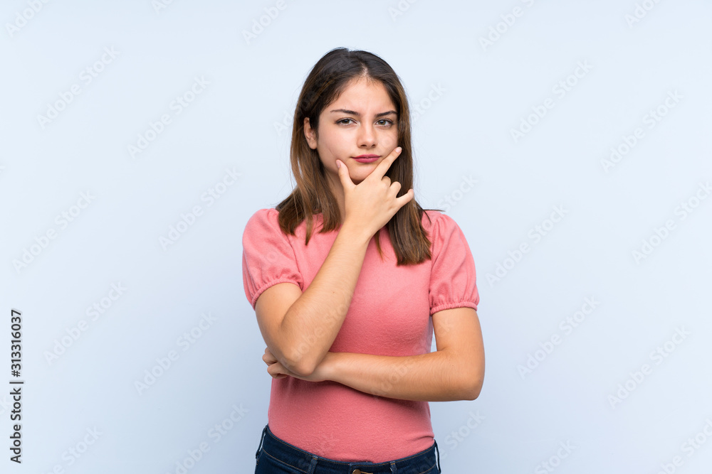 Young brunette girl over isolated blue background thinking an idea Young brunette girl over isolated blue background thinking an idea