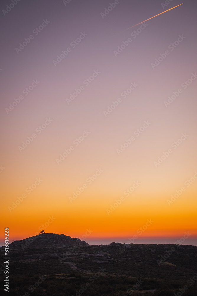 Silhueta de pequenas montanhas ao pôr do sol com céu limpo