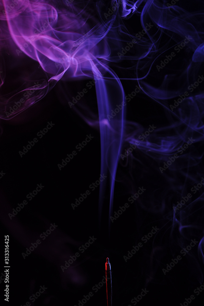 lilac smoke incense sticks on a black background. abstract figures of blue smoke on a black background