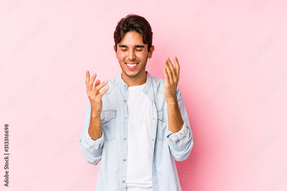 Young caucasian man posing in a pink background isolated joyful laughing a lot. Happiness concept. Young caucasian man posing in a pink background isolated joyful laughing a lot. Happiness concept.