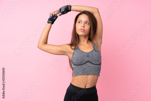 Fototapeta Naklejka Na Ścianę i Meble -  Young sport Brazilian girl over isolated pink background stretching