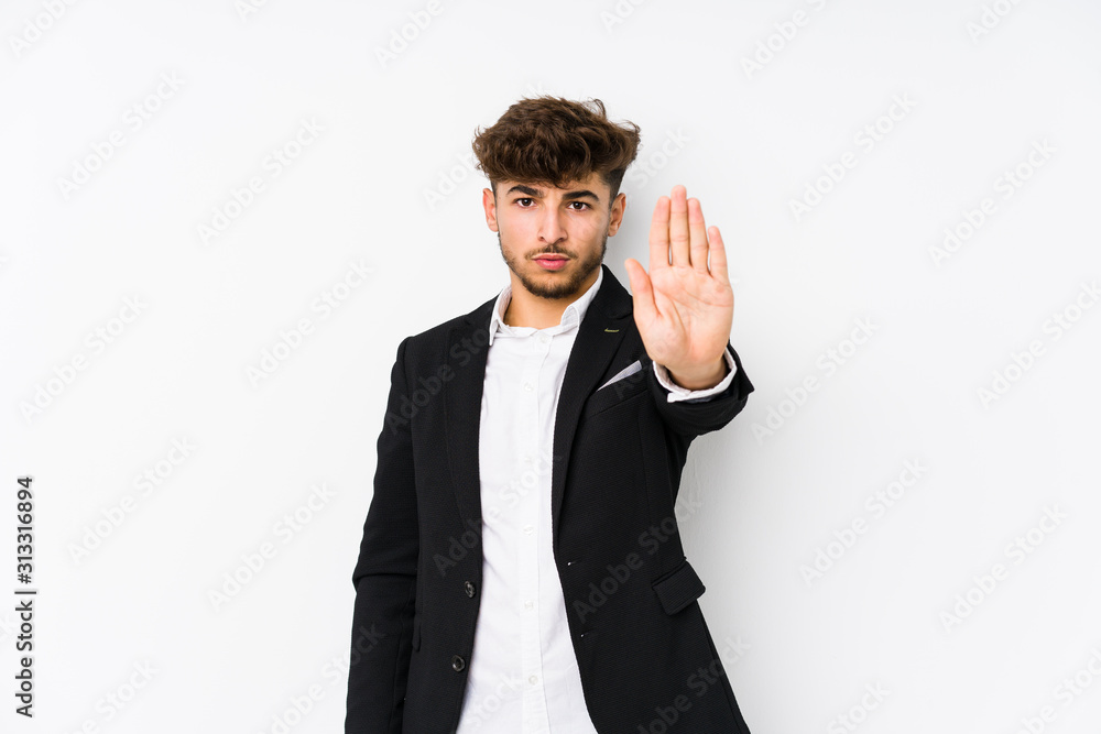 Young arabian business man isolated standing with outstretched hand showing stop sign, preventing you. Young arabian business man isolated standing with outstretched hand showing stop sign, preventing you.