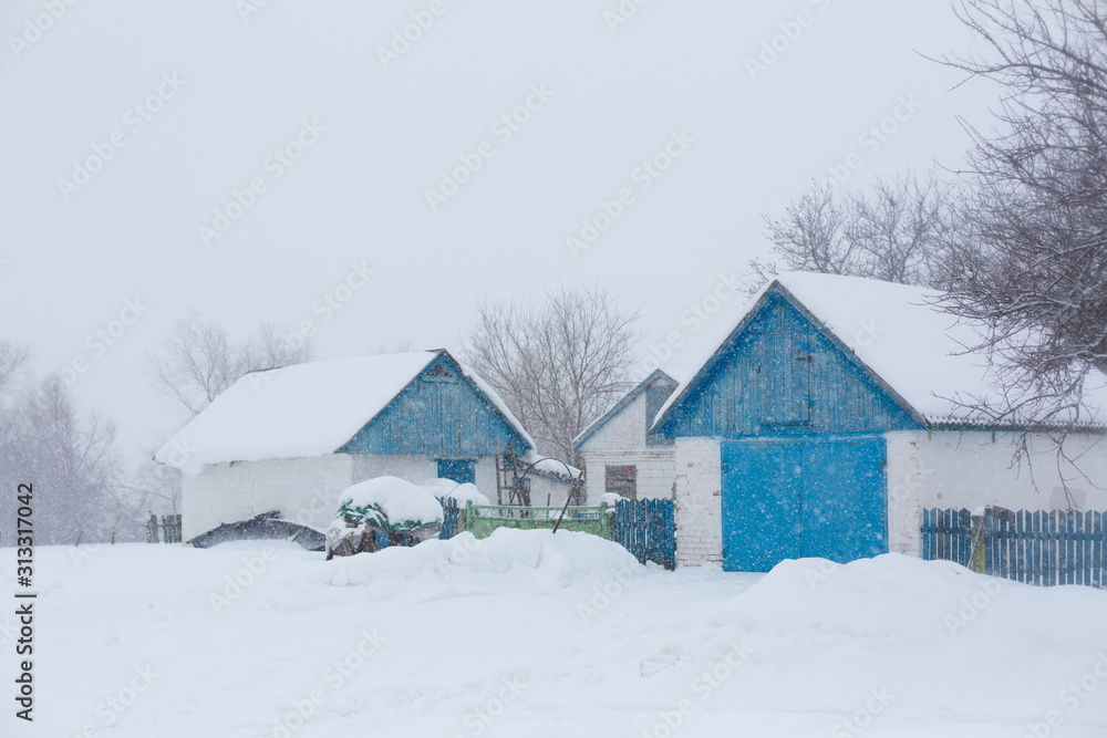 Old rural house. Snow blizzard. A lot of snow