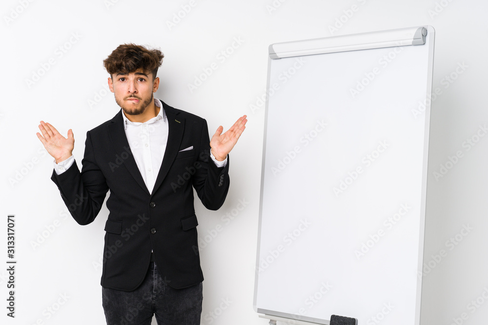 Young business coaching arabian man confused and doubtful shrugging shoulders to hold a copy space. Young business coaching arabian man confused and doubtful shrugging shoulders to hold a copy space.