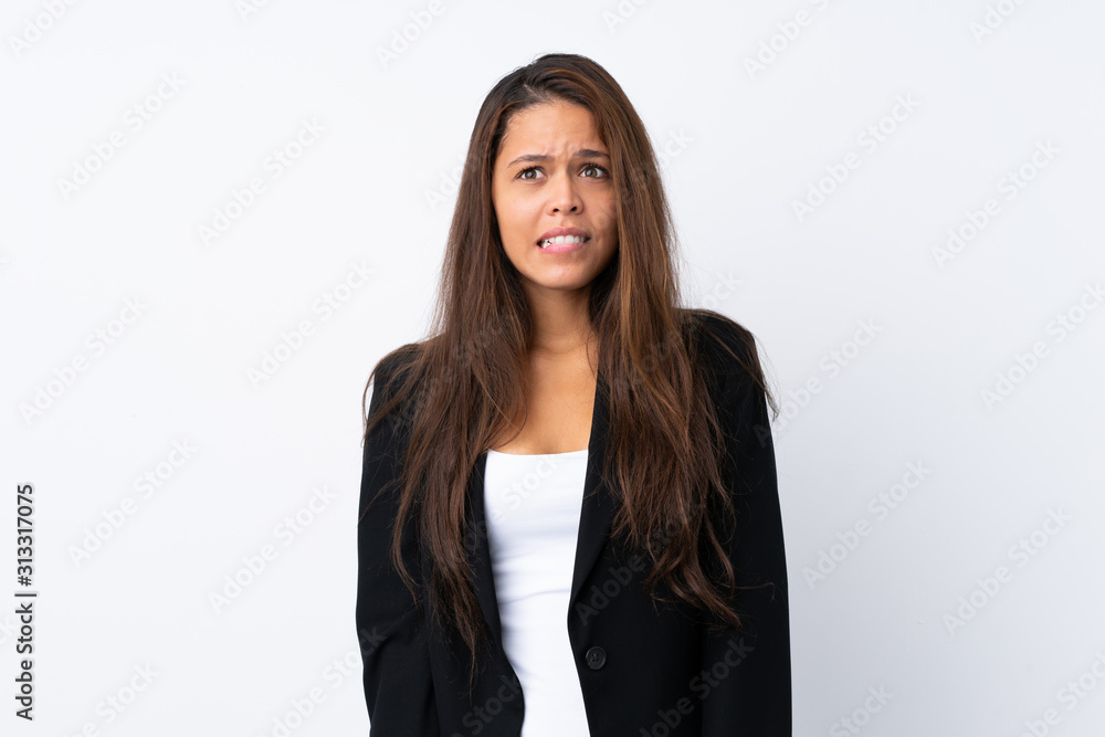 Young Brazilian girl with blazer over isolated white background having doubts and with confuse face expression Young Brazilian girl with blazer over isolated white background having doubts and with confuse face expression