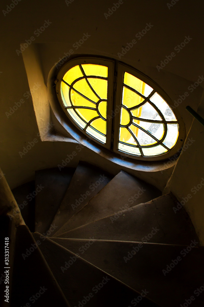 The architecture of the old city of Prague. Unusually round staircase window in the entrance hall