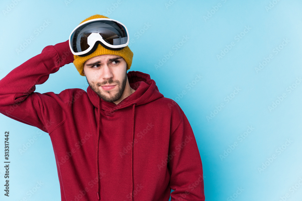 Young caucasian man wearing a ski clothes isolated touching back of head, thinking and making a choice.