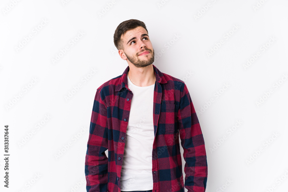 Young caucasian man posing in a white background isolated dreaming of achieving goals and purposes Young caucasian man posing in a white background isolated dreaming of achieving goals and purposes