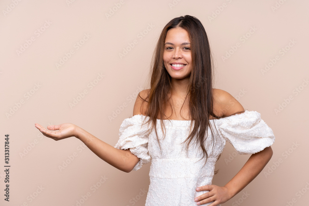 Young Brazilian girl over isolated background holding copyspace imaginary on the palm Young Brazilian girl over isolated background holding copyspace imaginary on the palm