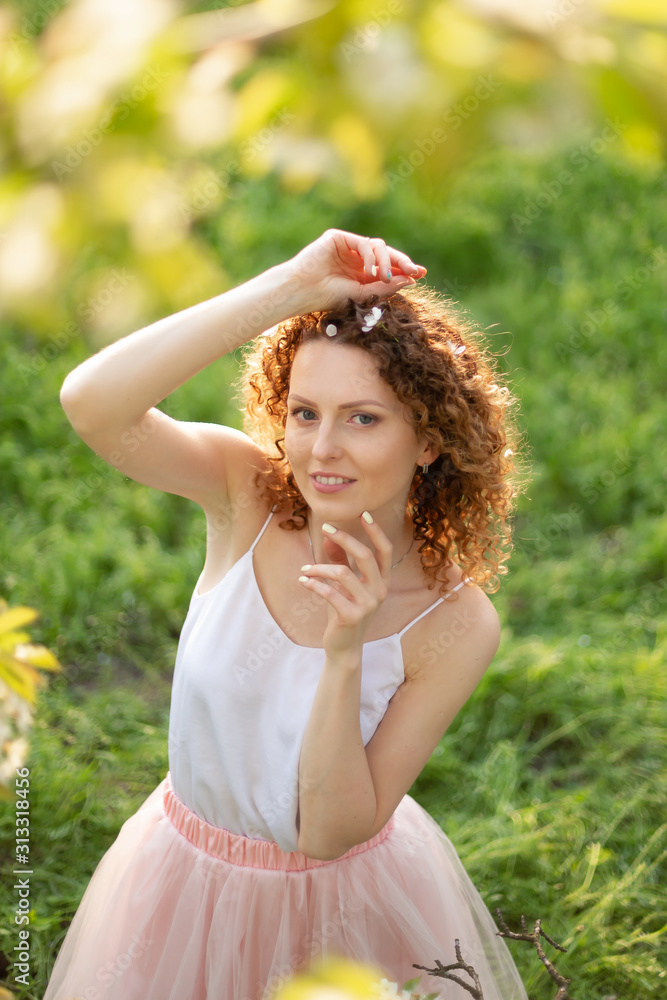 Young attractive girl walks in spring green park enjoying flowering nature. Healthy smiling girl spinning on the spring lawn. Allergy without Young attractive girl walks in spring green park enjoying flowering nature. Healthy smiling girl spinning on the spring lawn. Allergy without