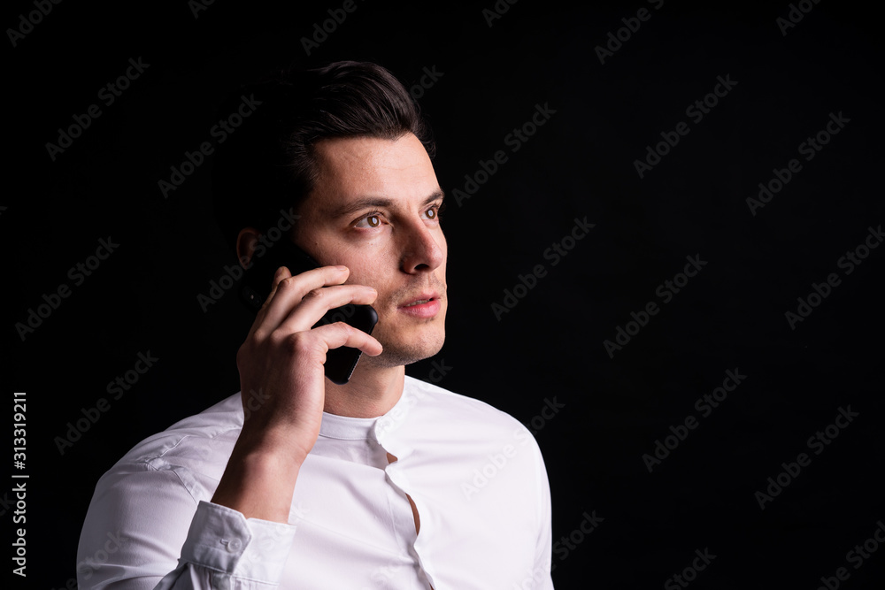 Isolated young man with phone in hands look somewehere and thinking Isolated young man with phone in hands look somewehere and thinking