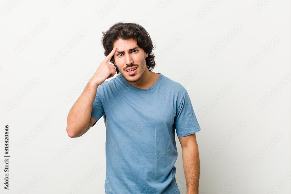 Young handsome man against a white background showing a disappointment gesture with forefinger. Young handsome man against a white background showing a disappointment gesture with forefinger.